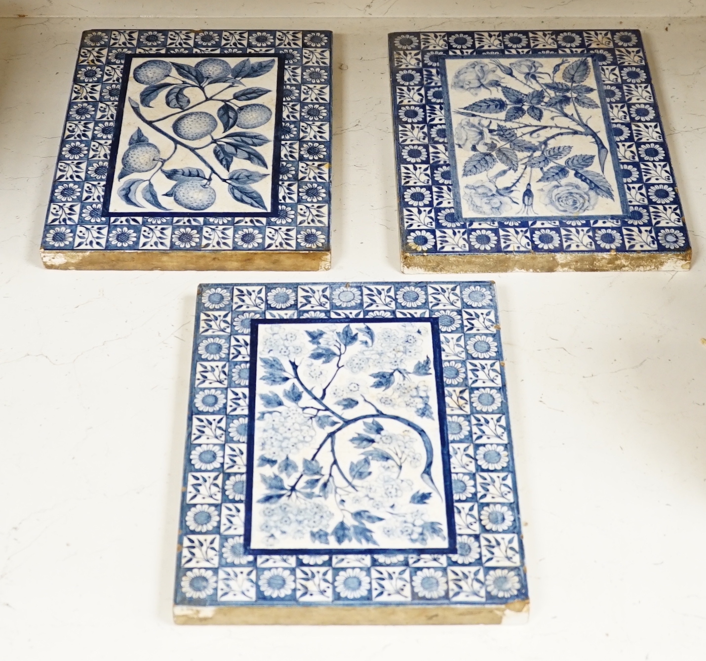 Three Victorian blue and white Mintons tiles decorated with flowers and fruit, each stamped to the base, each 29cm x 22cm